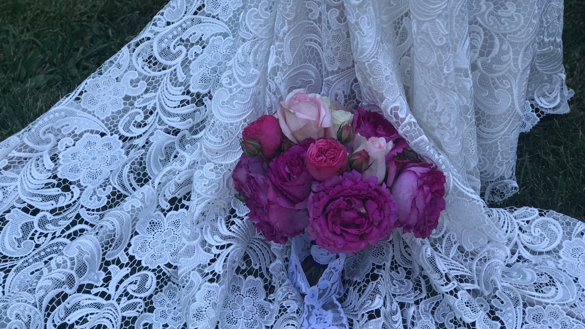 Wedding bouquet resting on a lace gown