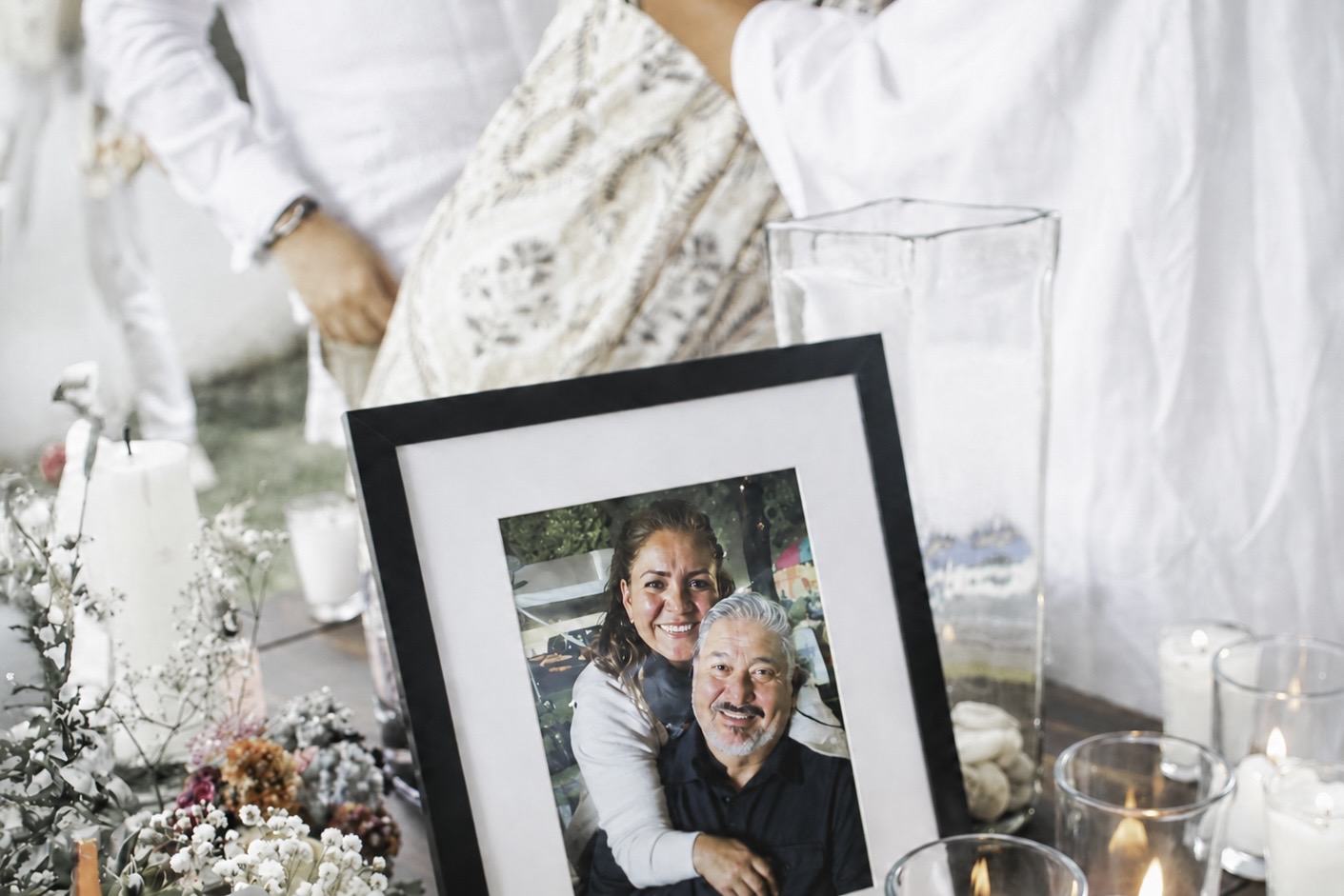 Memorial table with framed photograph, flowers, and candles